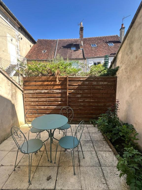 a table and two chairs on a patio at Maison de charme Centre-Ville - WIFI Netflix - Terrasse - 2 cours extérieures in Auxerre