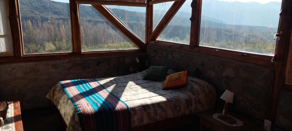 a bedroom with a bed and a large window at Cabaña La Mostacita - Complejo El Taller in Potrerillos