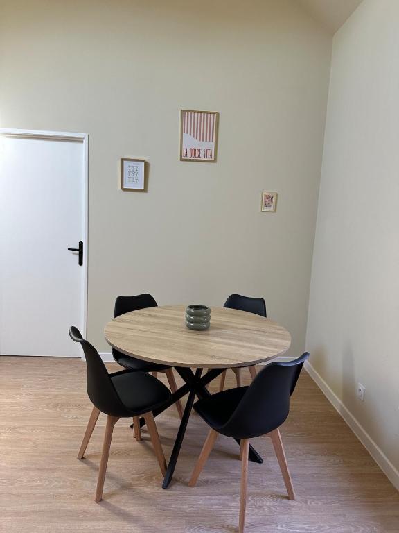 a wooden table and chairs in a room at Appartement 2 chambres gare chateaucreux in Saint-Étienne