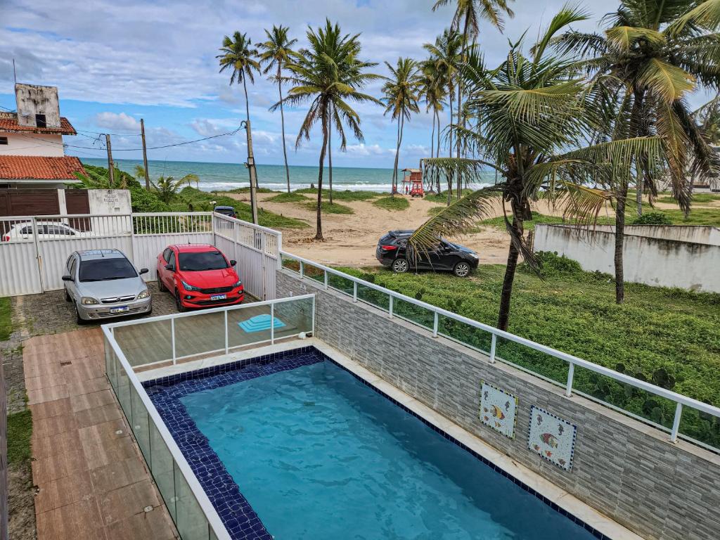 a swimming pool with a view of the beach at Porto de Galinhas Pé na Areia Belize in Porto De Galinhas