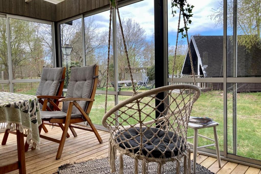 a screened in porch with two chairs and a table at Near beach summer house in Farhultsbaden in Farhult