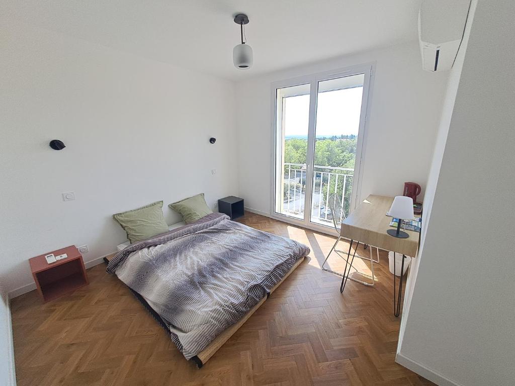 Un dormitorio con una cama y una ventana grande. en Chambre d'hôte centre-ville Manosque, en Manosque
