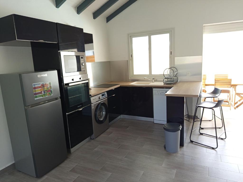 a kitchen with a refrigerator and a dishwasher at Villa Lilisse in Le Moule