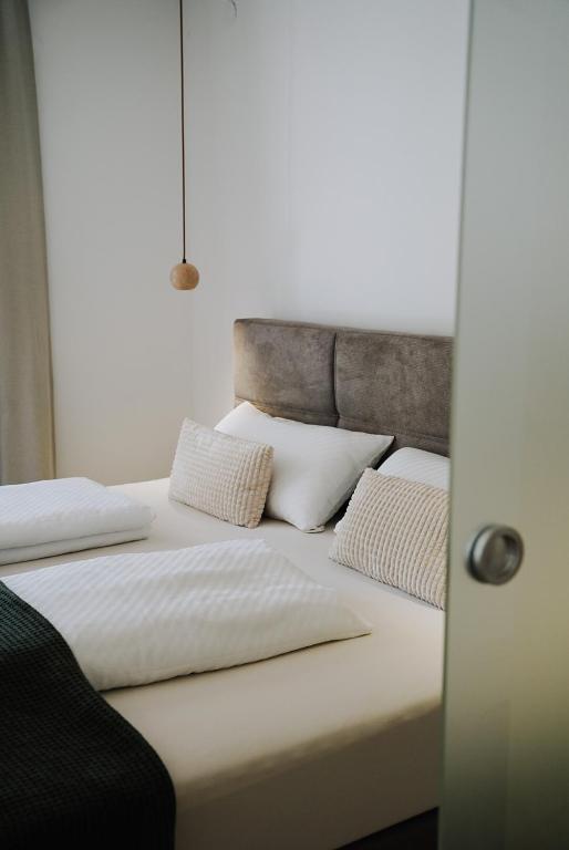 a bed with white sheets and pillows on it at Ferienwohnung Goldtann in Elzach