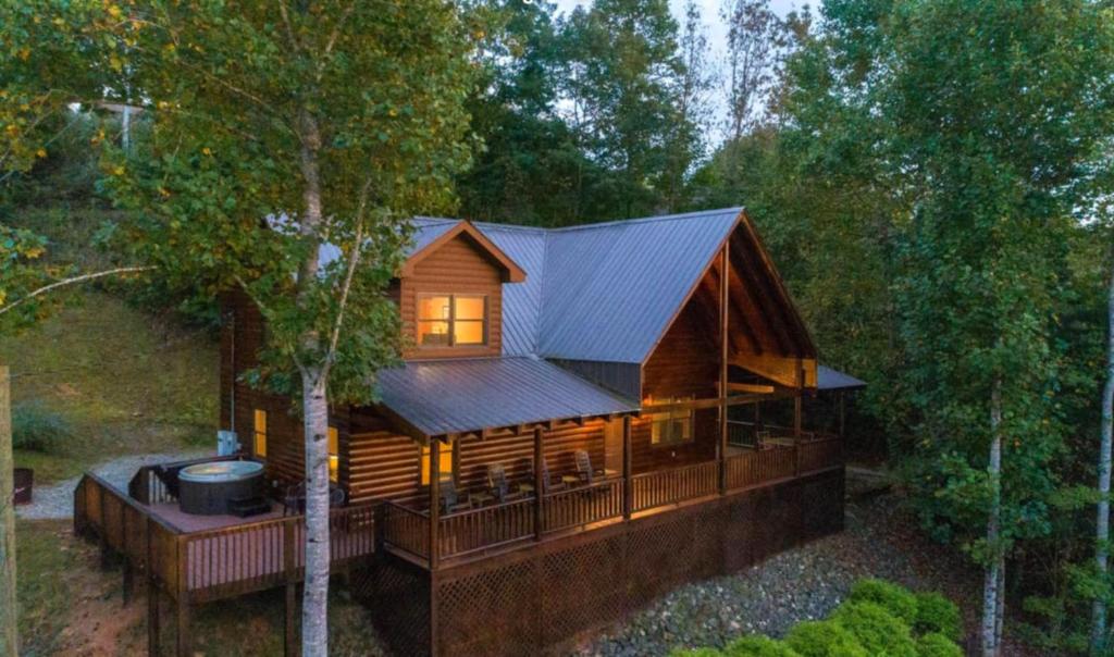 una grande baita di legno nel bosco con una griglia di Bear Cove Cabin a Wilmot