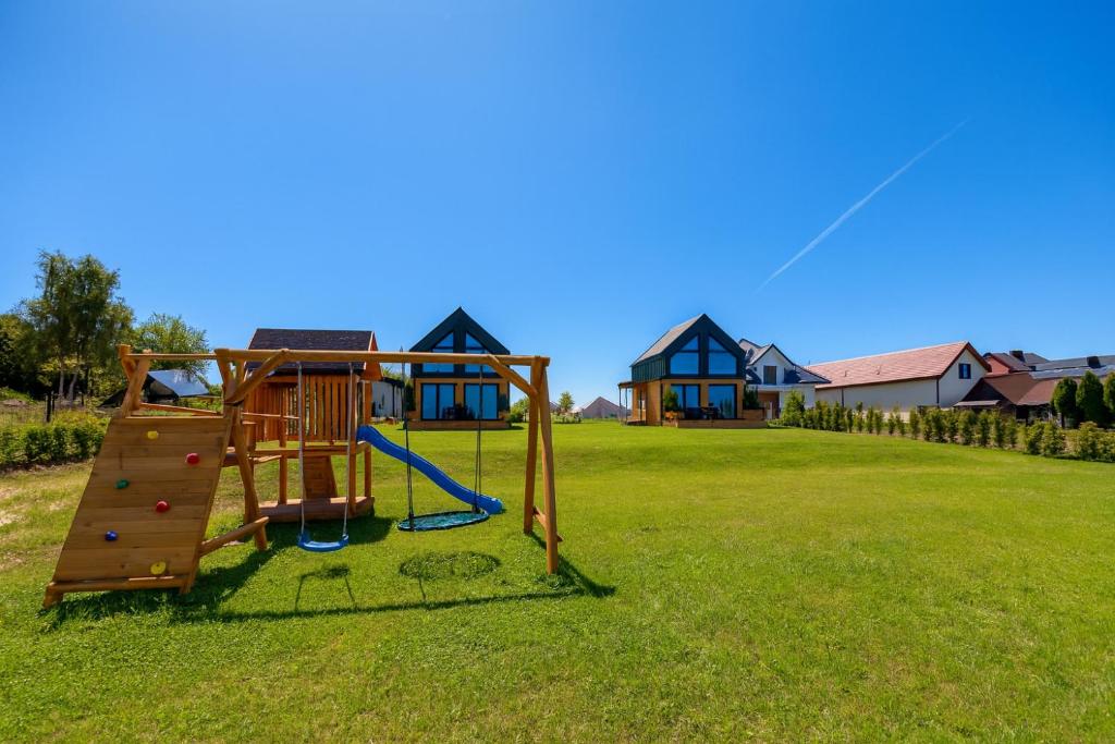a playground in a yard with a house at Domki Baby Jagi in Krajno Pierwsze