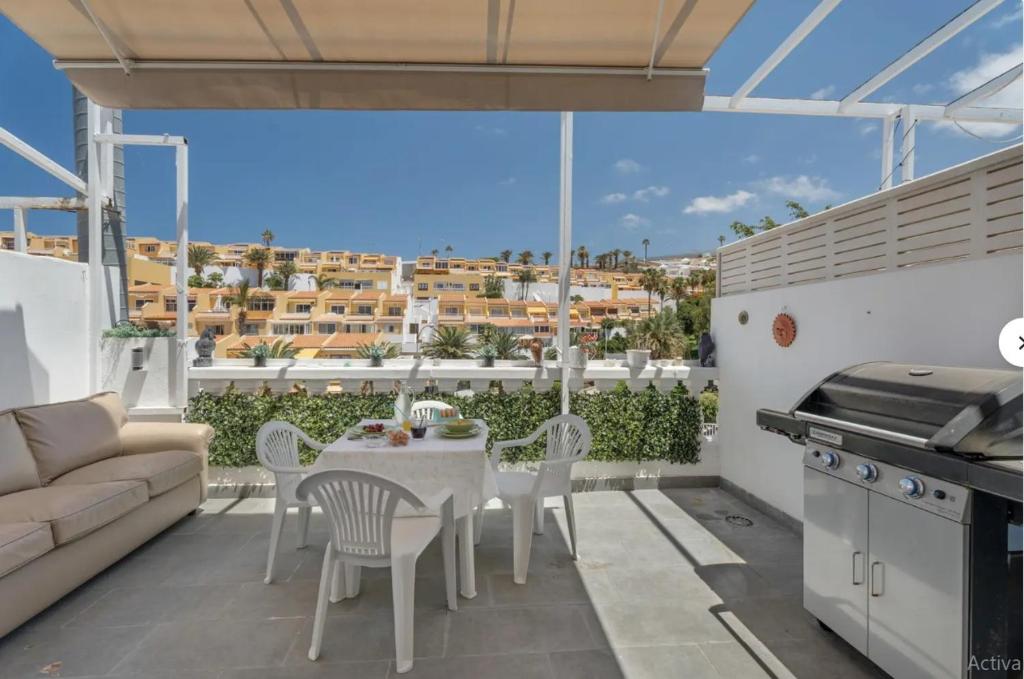 a patio with a table and chairs and a couch at Sun Garden in Adeje