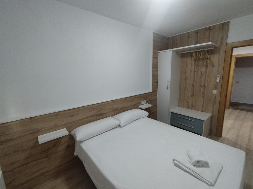 阿尔巴塞特Precioso Apartamento centrico con 2 dormitorios的卧室里有一张白色的床和一面镜子