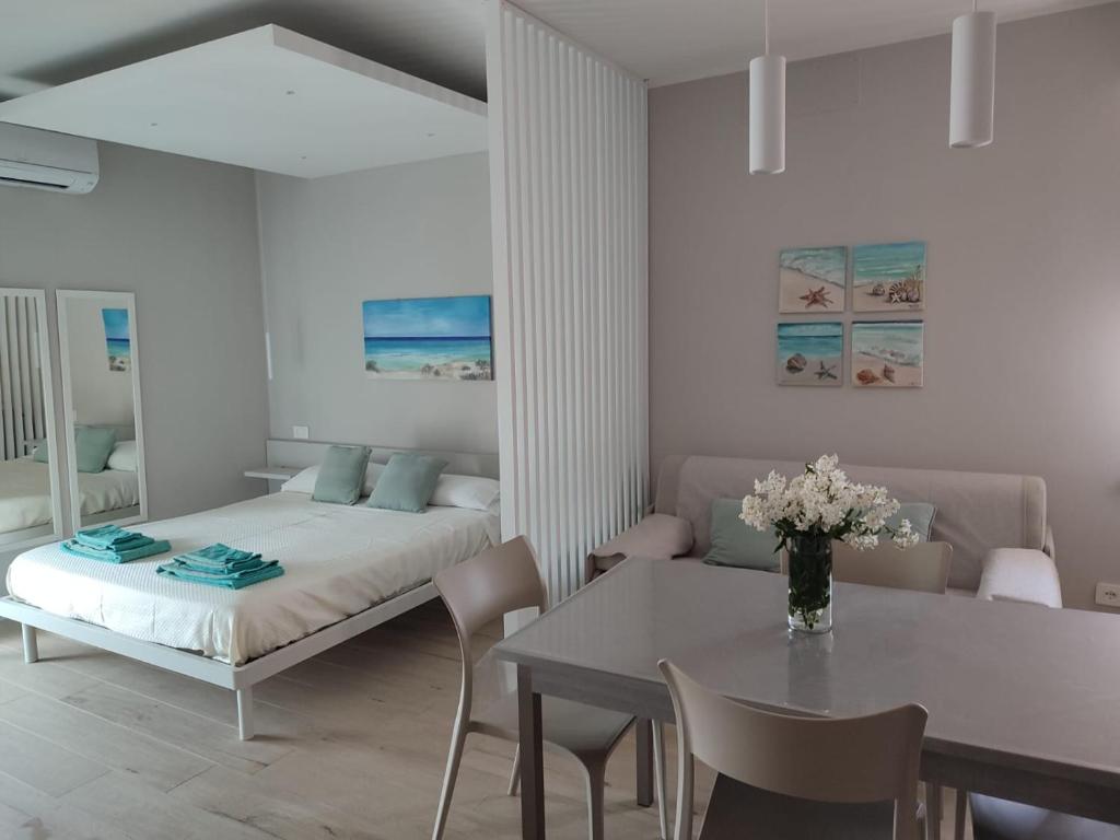 una camera da letto con un letto, un tavolo e delle sedie di Due passi dal mare a Bellaria-Igea Marina