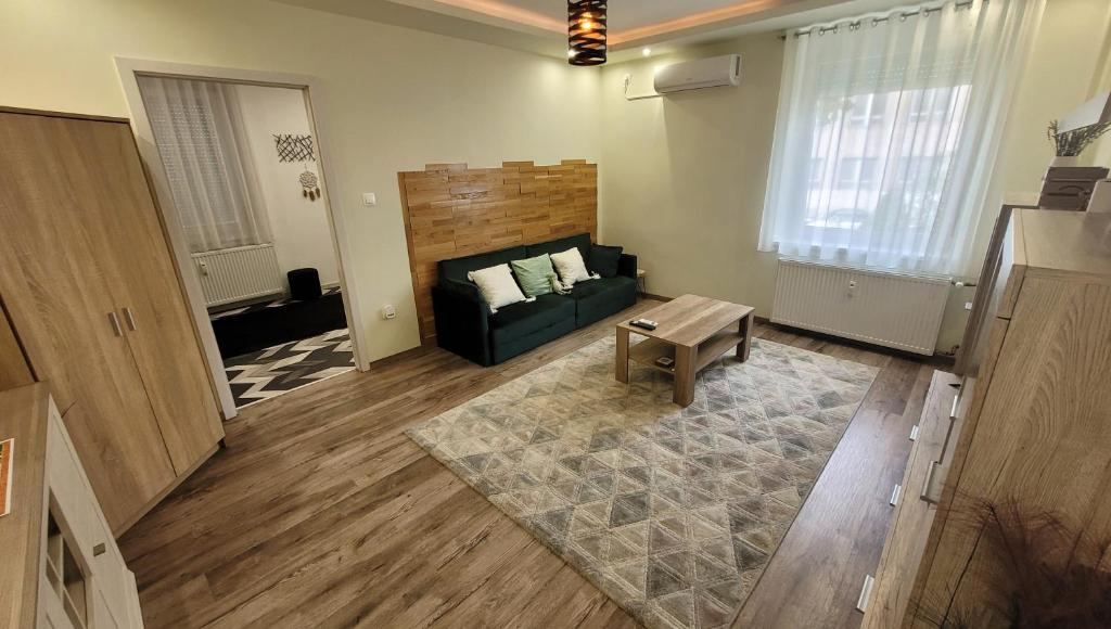 una sala de estar con un sofá y una mesa en Oliva Apartman, en Salgótarján