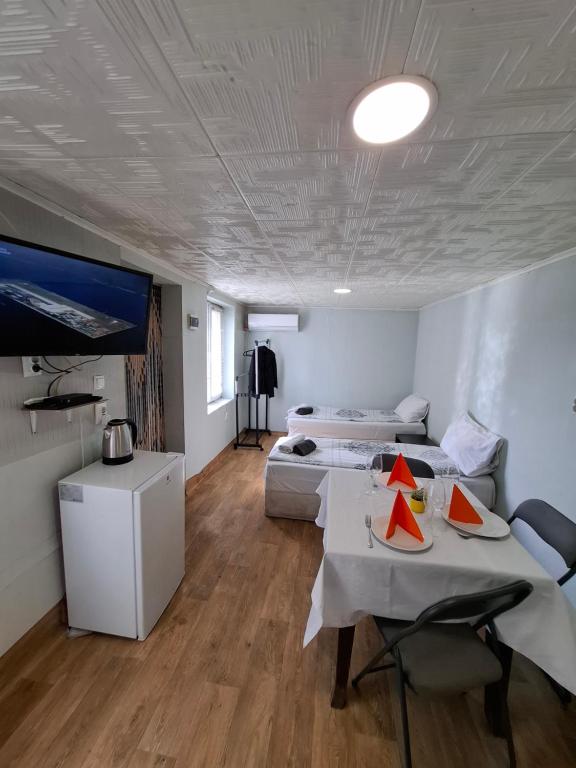 a room with two beds and a table and a tv at La vie in Opanets