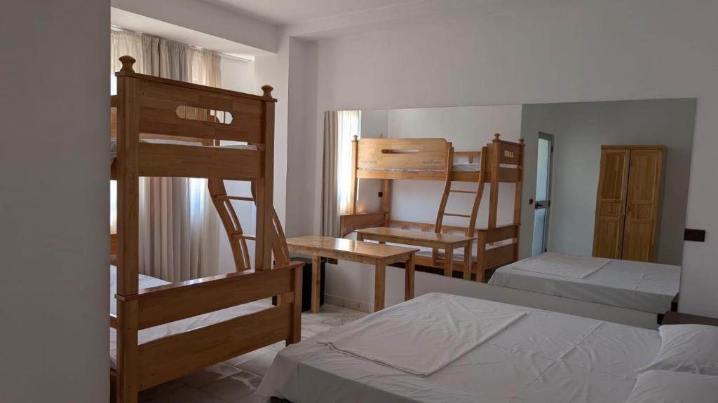 a room with two bunk beds and a bed and a desk at Vila Kastriotet-Hotel in Lezhë