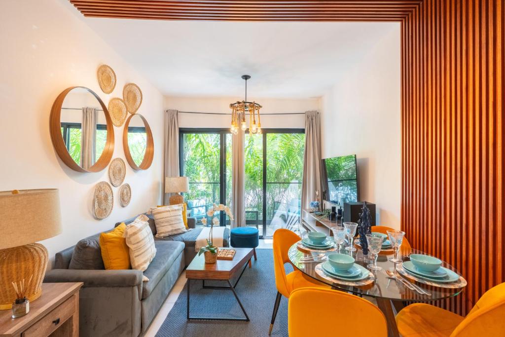 uma sala de estar com uma mesa e um sofá em Thematic beach apartment in CapCana area em Punta Cana