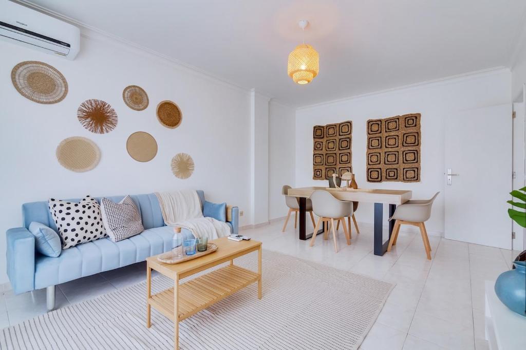 a living room with a blue couch and a table at Brisa Algarvia 2 in Faro