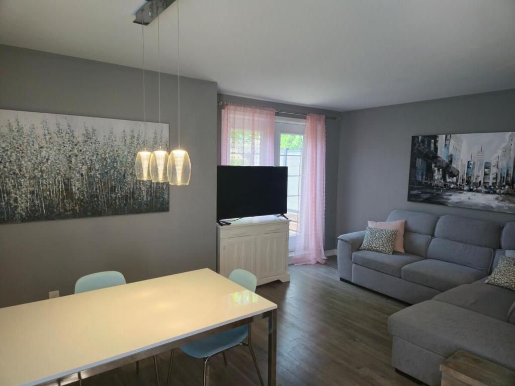 TV a/nebo společenská místnost v ubytování Cozy Digital Nomad Apartment in Montreal Riv-Sud