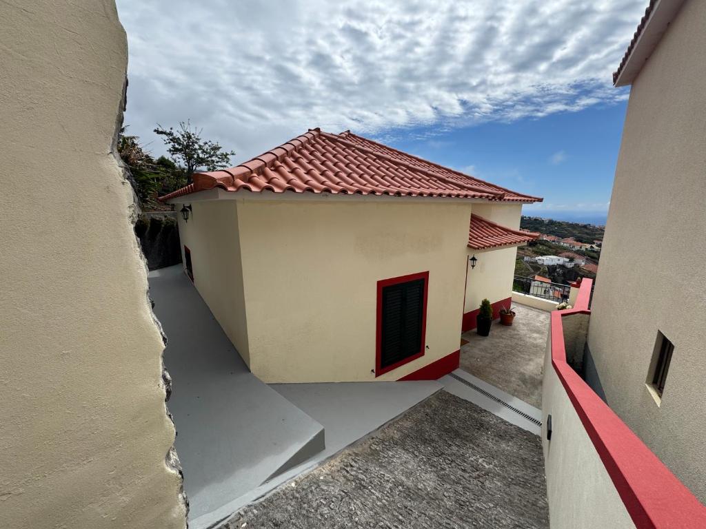 una piccola casa bianca con tetto rosso di Pôr do Sol a Estreito da Calheta