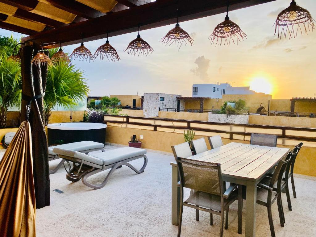 a patio with a table and chairs on a roof at Lunada PH with Private Rooftop and Jacuzzi by Caribe Rentas in Playa del Carmen