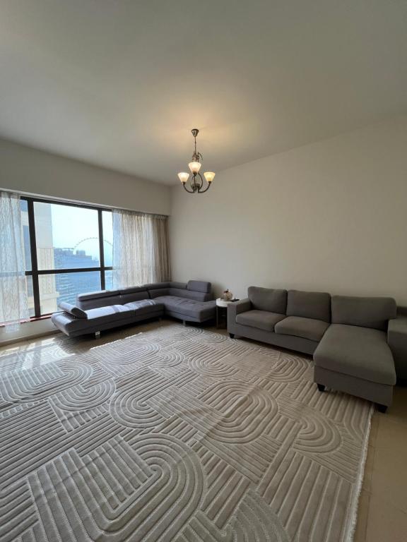 a living room with a couch and a rug at JBR Skyview Rooms in Dubai