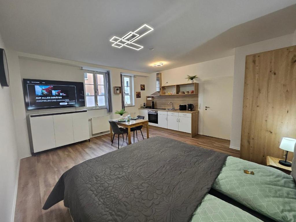 a bedroom with a large bed and a kitchen at Herzstück in Ansbach