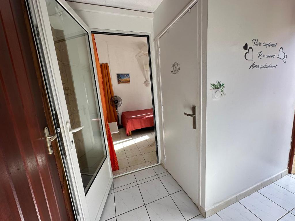 a hallway with a glass door leading to a bedroom at Appt F2 BELLISSIMA in Baie-Mahault
