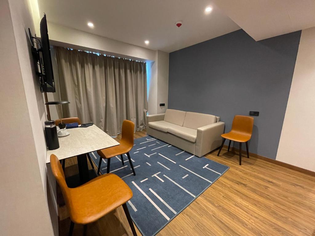 a living room with a couch and a table and chairs at Marriot by Batumi in Batumi
