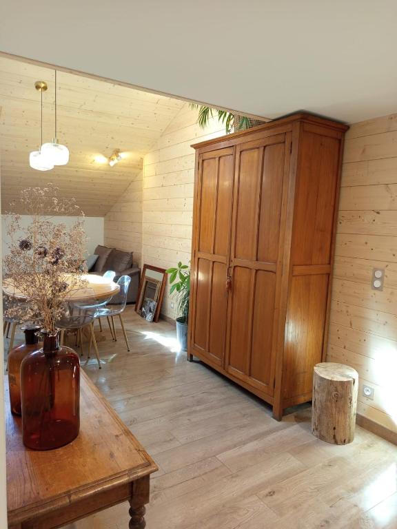 a room with a large wooden cabinet and a table at Le Chablis étoilé in Champagnole