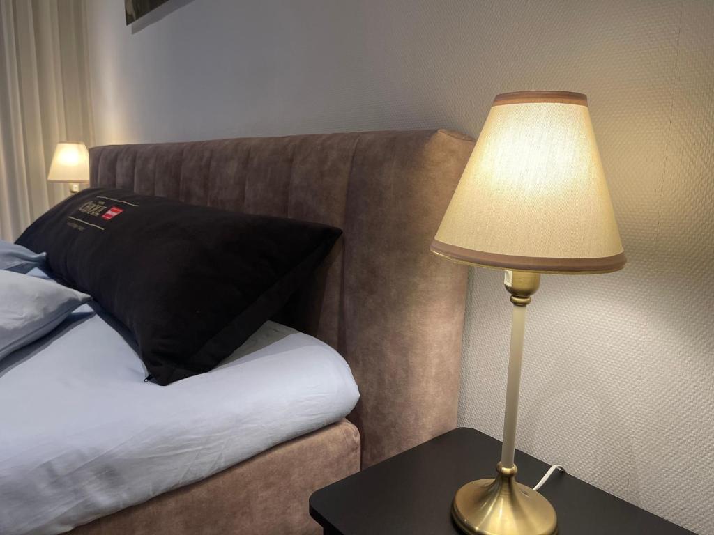 a lamp sitting on a table next to a bed at Weezen by Gracht in Zwolle