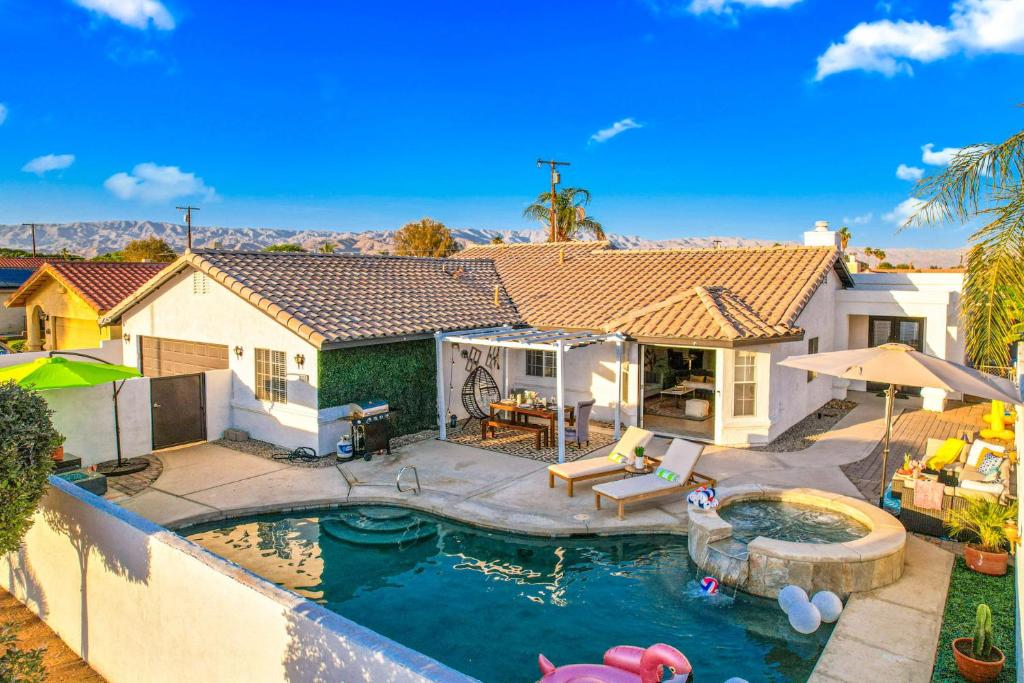 a house with a swimming pool and a backyard at 4BR Desert Escape PoolGame Room in Bermuda Dunes