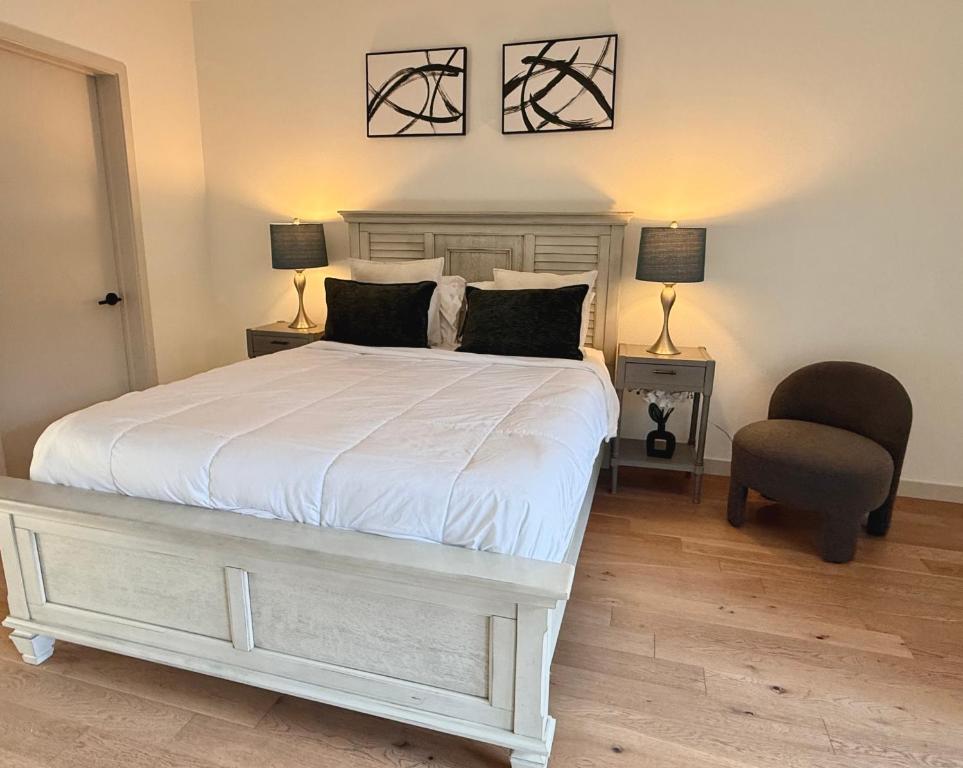 Un dormitorio con una cama blanca y una silla. en Hollywood Walk of Fame I Pool View I Fitness Center I Free Parking!, en Los Ángeles