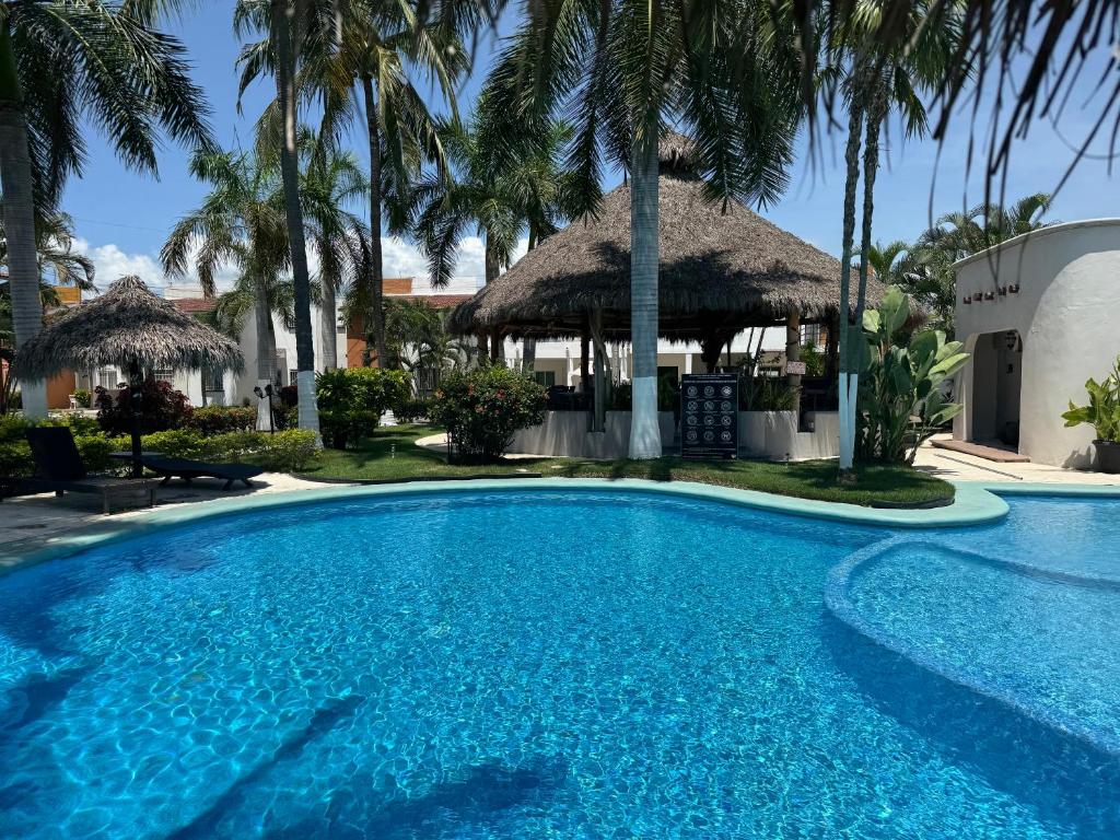 a pool with a gazebo and palm trees at Casa Condo Diamante, Nueva Vallarta in Nuevo Vallarta 