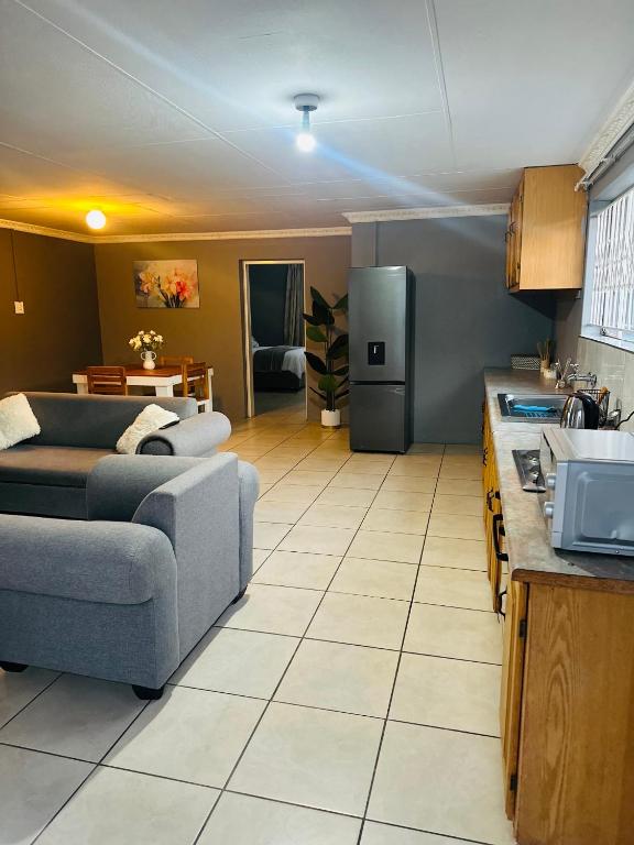 ein Wohnzimmer mit Couch und Küche in der Unterkunft SerenityStay 37 on Zebra in Polokwane