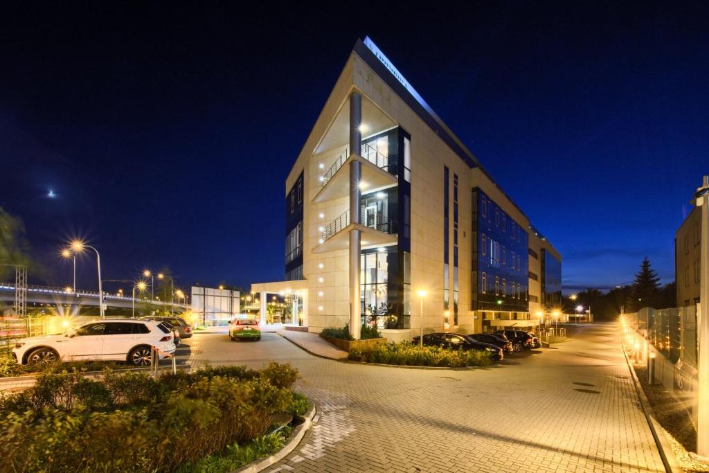 a large building with a car parked in a parking lot at Al. Jerozolimskie 216 Perfect Apart in Warsaw