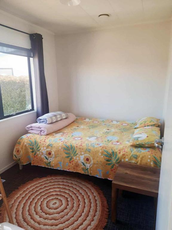 a small bedroom with a bed and a window at Double Room in Tauranga