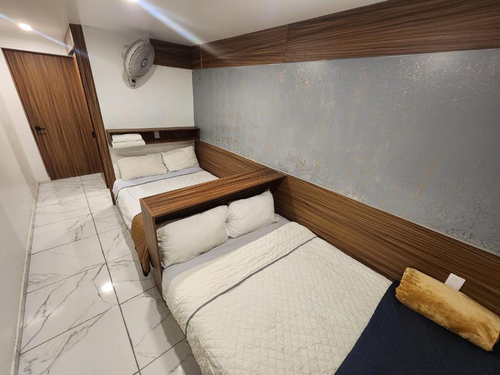 a small room with two beds in it at Hotel Alambique Arandas in Arandas