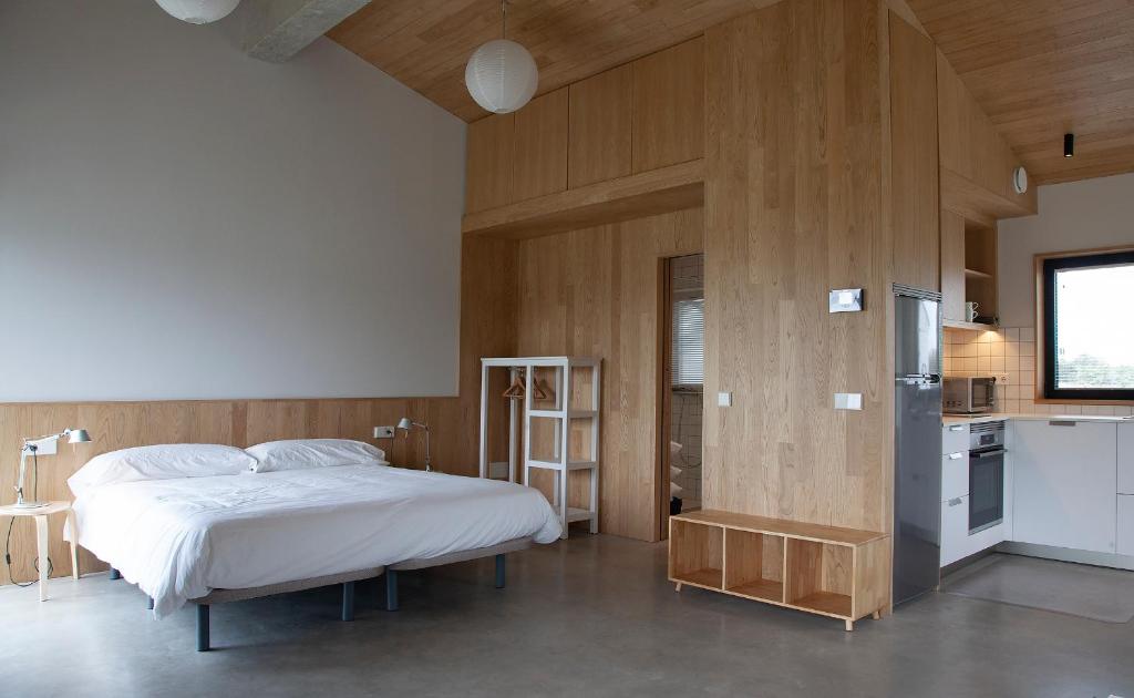 a bedroom with a large bed and a kitchen at Barrio del Norte in Villademoros