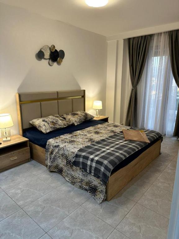 a bedroom with a bed and two night stands and two lamps at Yasmina apart in Bejaïa