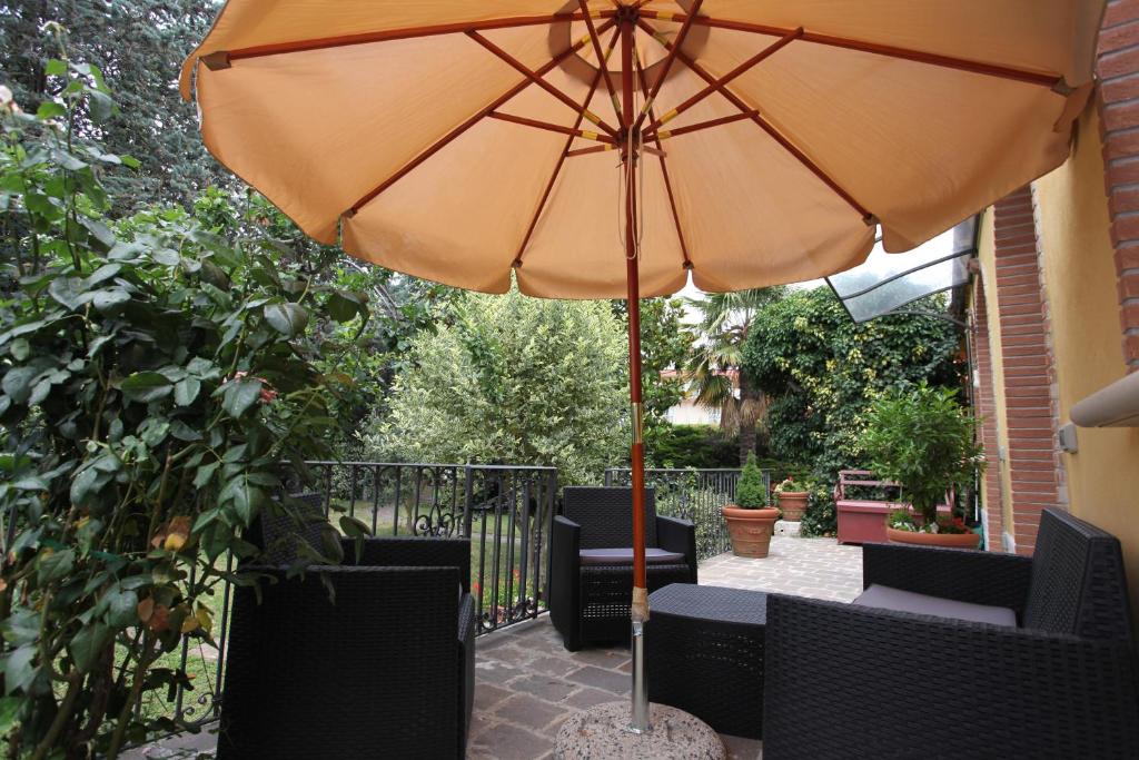 un ombrellone arancione seduto su un patio con sedie di Il giardino della Contessa a Isernia