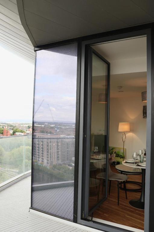 a balcony with sliding glass doors with a view of a table at Luxury penthouse with the best view in Manchester in Manchester