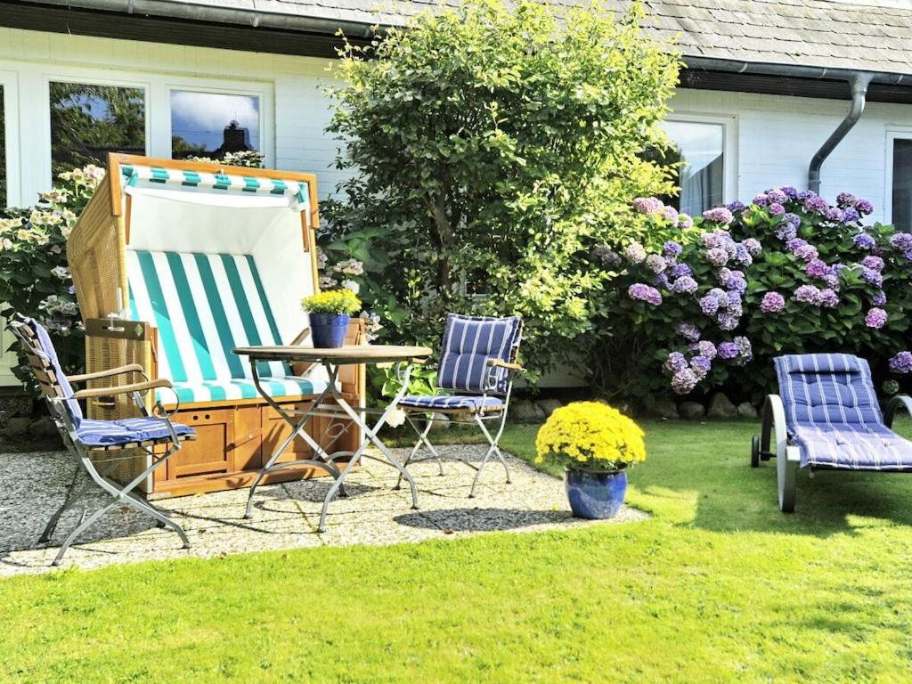 un patio avec deux chaises et une table dans une cour dans l'établissement Süderhof Apartment 3, à Keitum