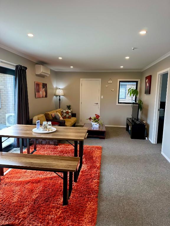 a living room with a table and a couch at The heart of Palmerston North in Palmerston North