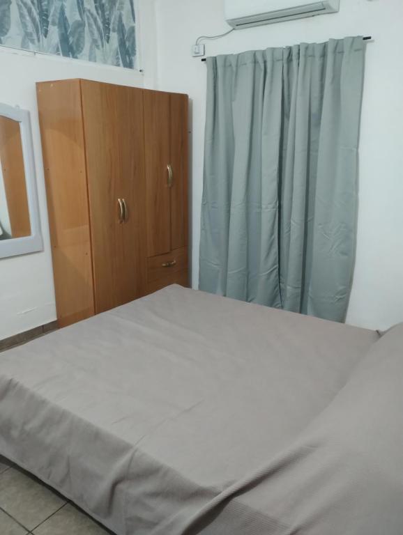 a bedroom with a bed and a wooden cabinet at Florida 68 B in Puerto Iguazú