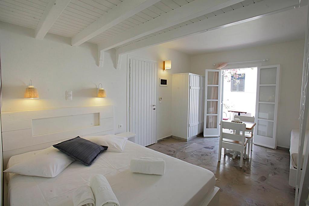 um quarto branco com uma cama branca e uma secretária em Glaros Studios em Naxos Chora
