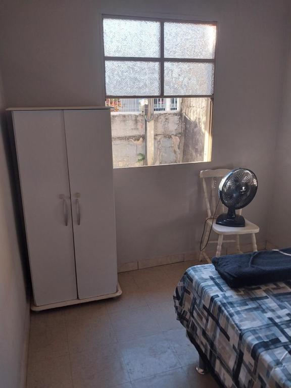 1 dormitorio con armario blanco y ventana en Casa Aconchegante, en Nova Odessa