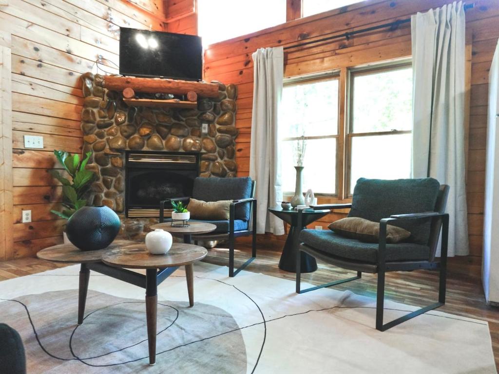 Una sala de estar con sillas y chimenea. en Smoky Haven Cabin, en Sevierville