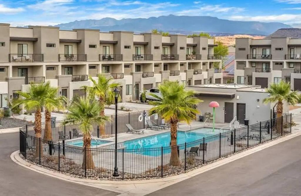 an apartment complex with a pool and palm trees at Spacious 5BR Resort Waterpark Access Sleeps 16 in Saint George Municipal Airport