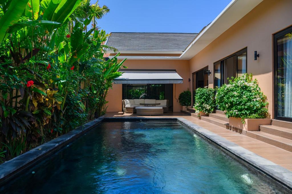 a swimming pool in the backyard of a house at Black Pool Situé à SANUR 4BR in Sanur