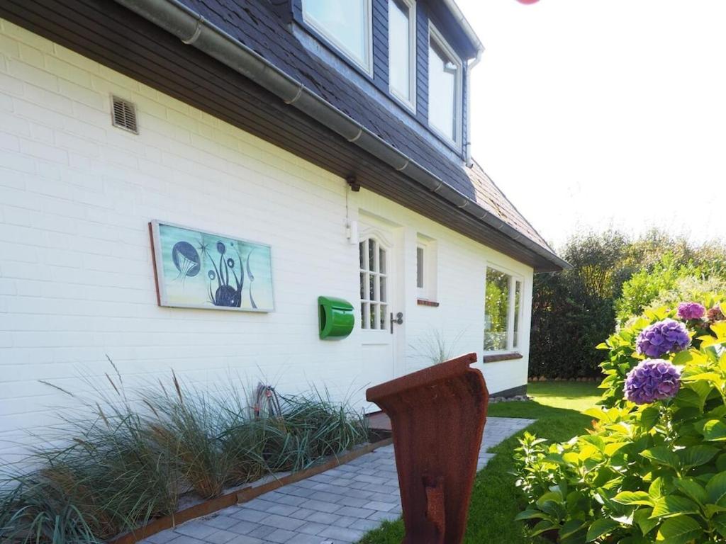 une maison blanche avec une photo sur le côté dans l'établissement Süderhof Apartment 1, à Keitum