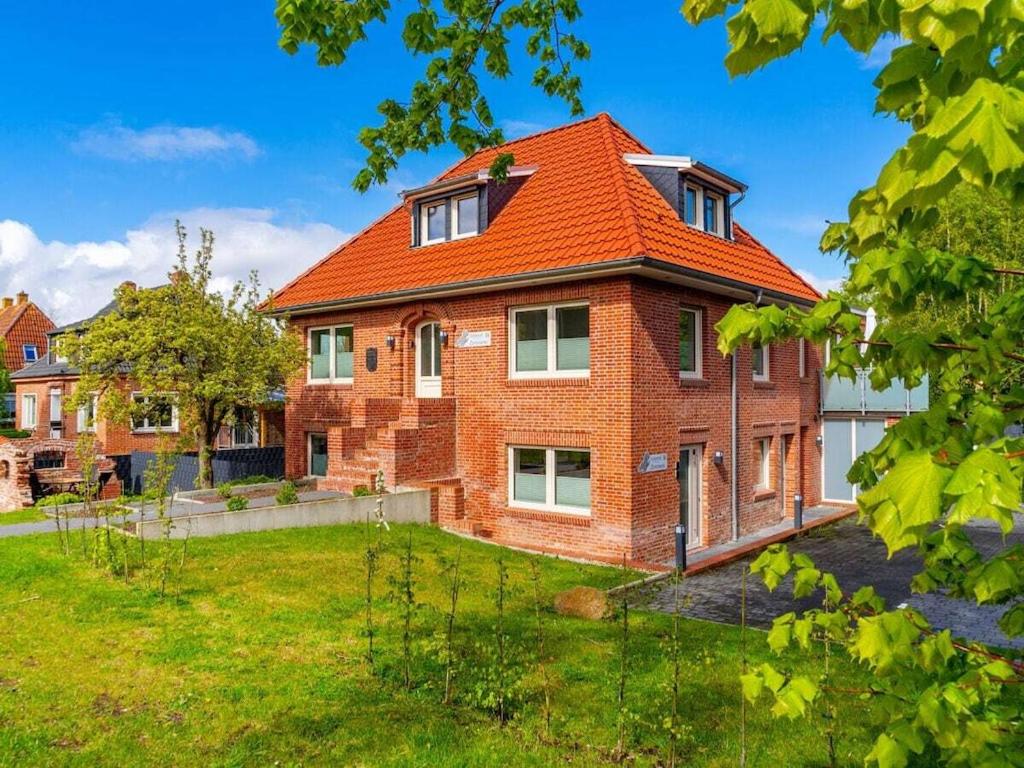 a brick house with an orange roof at Holiday apartment with 2 bedrooms in Greetsiel