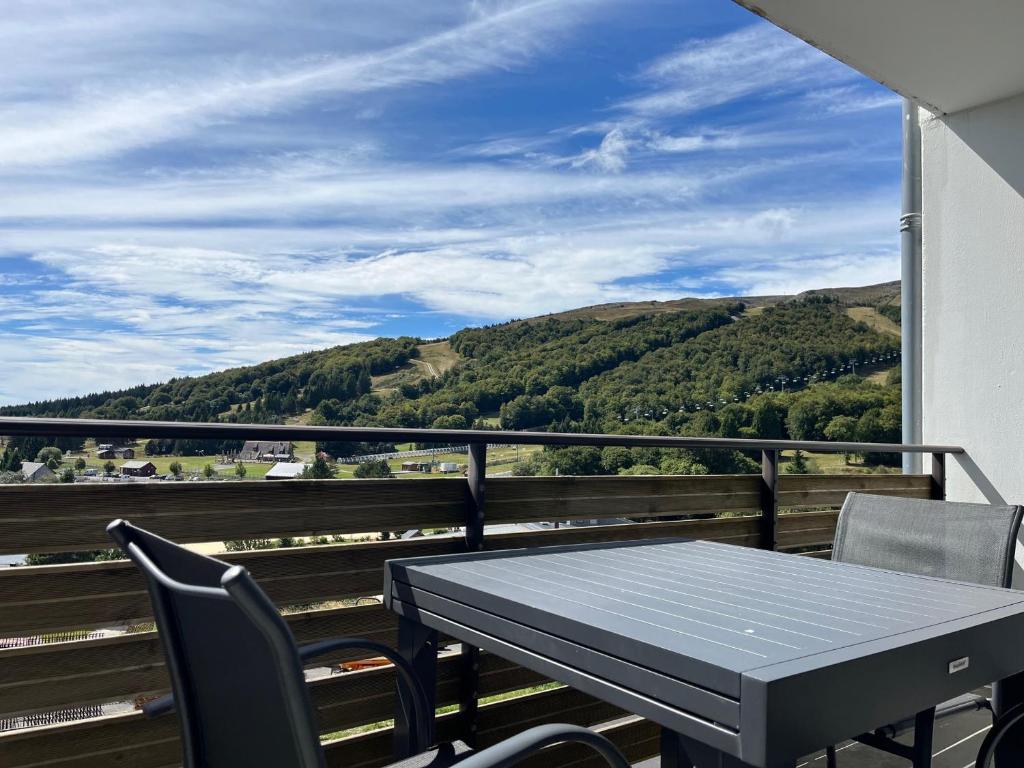 a table and chairs on a balcony with a view at Appartement cosy 6 pers au pied du Lac à Super Besse - FR-1-814-151 in Super Besse