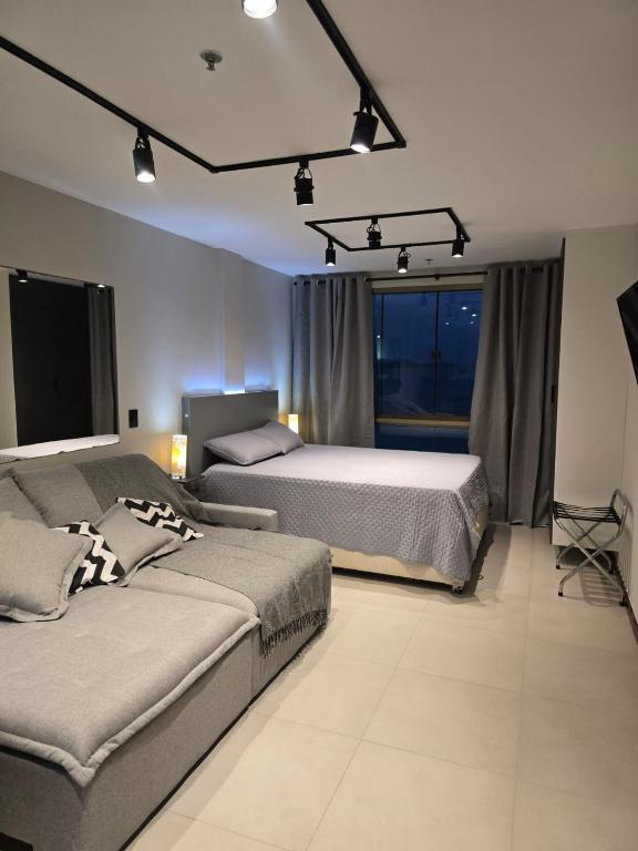 a bedroom with two beds and a tv in it at Loft Prainha in Arraial do Cabo